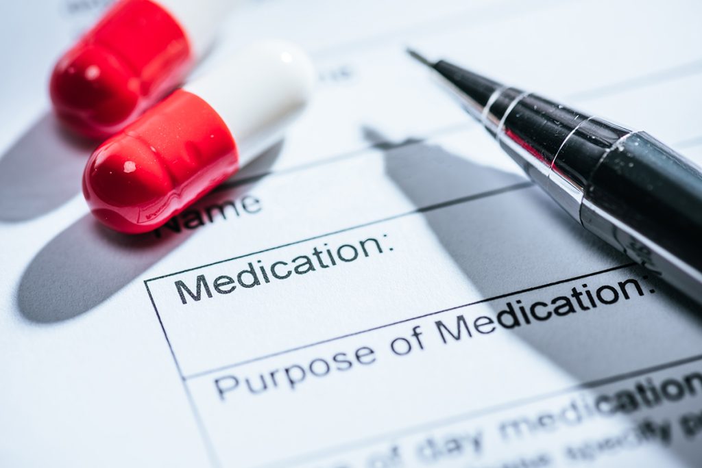 close up view of medical questionnaire, red pills and on table