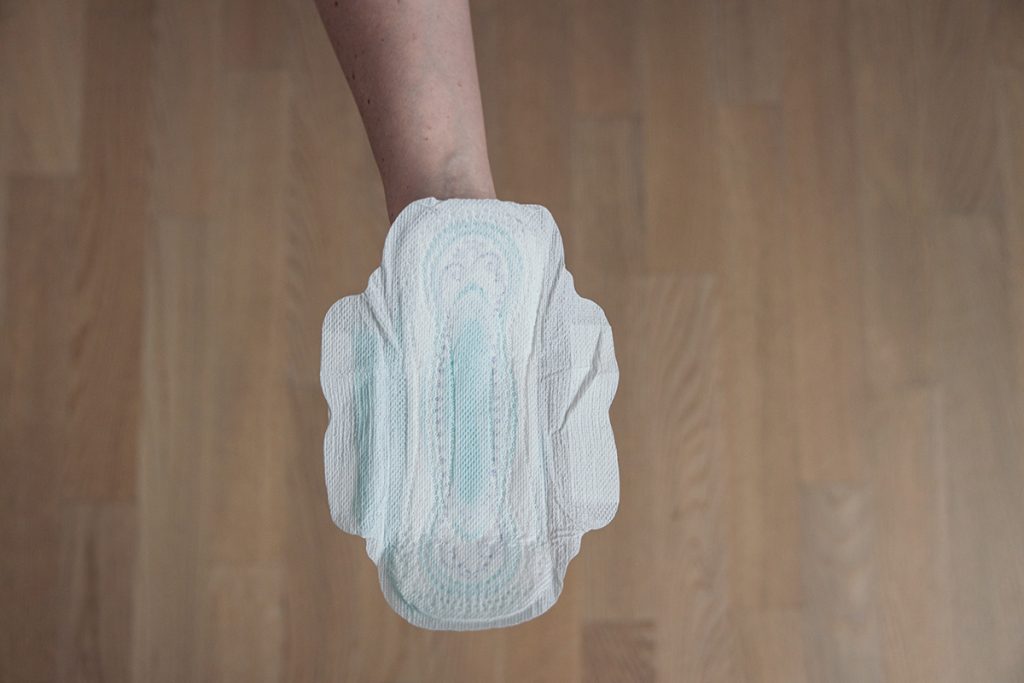 Hand holding a clean menstrual pad